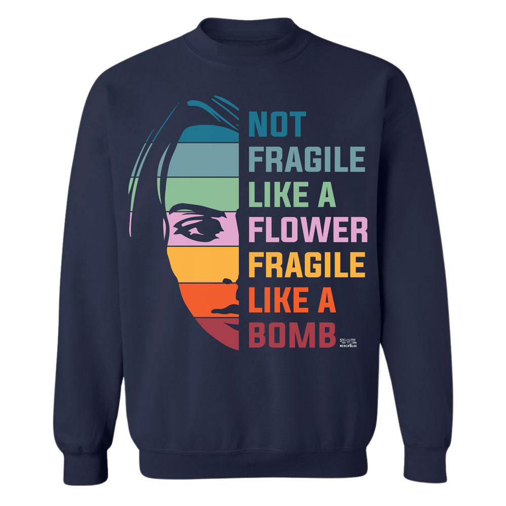 A navy crewneck sweater shows the half face of a woman and the words "Not Fragile Like a Flower, Fragile Like a Bomb", in many striped colors.